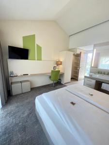 a bedroom with a white bed and a green chair at Hotel-Restaurant Krüger in Grafhorst +24 photos