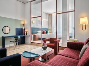 a hotel room with a couch and a table at Kimpton Main Frankfurt by IHG in Frankfurt