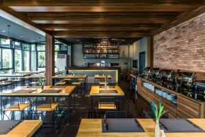 武里南Cresco Hotel Buriram的一间有桌椅和砖墙的餐厅