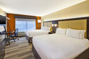 a hotel room with two beds and a desk at Holiday Inn Express & Suites Chicago-Midway Airport by IHG in Bedford Park +29 photos