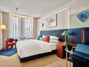 a hotel room with a bed and a desk at Kimpton Main Frankfurt by IHG in Frankfurt