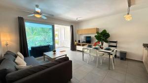a living room with a couch and a table at Experience the Pool View Dream at Estrella Dominicus in Bayahibe