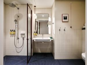 a bathroom with a sink and a shower at Kimpton Main Frankfurt by IHG in Frankfurt +125 photos