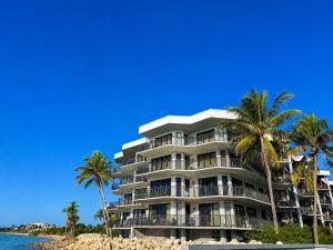 a large building on the beach with palm trees at Paradise Found Cayo Hueso in Key West
