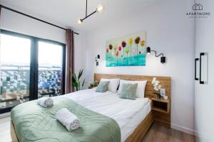 a bedroom with a large bed and a window at City Center - AURA by Apartmore in Gdańsk