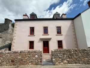 a white house with red windows and a stone wall at The Old Manse, Horton in Horton