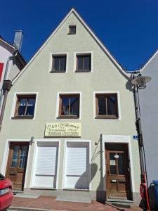 a building with white doors and a sign on it at Ferienwohnung HEIDI in Donauwörth +4 photos