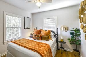 a bedroom with a bed with orange blankets and pillows at ~ 12 Mi to Disney: Downtown Winter Garden Cottage! in Orlando