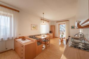 a kitchen and living room with a couch and a table at Apartments Haus Weinberg in Caldaro