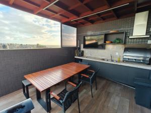 a kitchen with a wooden table and chairs at PARK DEL PRADO - Conforto pertinho do mar in Cabedelo