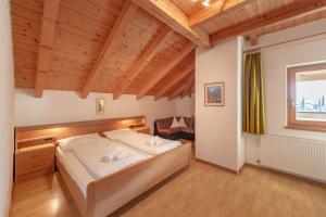 a bedroom with a bed in a room with wooden ceilings at Apartments Haus Weinberg in Caldaro