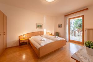 a bedroom with a bed and a large window at Apartments Haus Weinberg in Caldaro