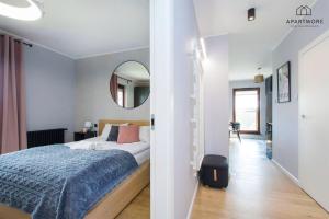 a bedroom with a bed and a mirror at City Center - AURA by Apartmore in Gdańsk +16 photos