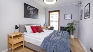 a bedroom with a bed with red pillows on it at City Center - AURA by Apartmore in Gdańsk