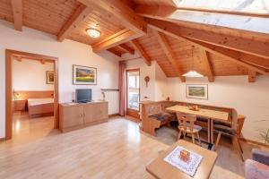 a living room with wooden ceilings and a table at Apartments Haus Weinberg in Caldaro