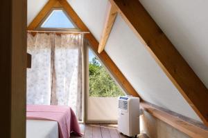 a attic room with a window and a bed at Glamping Le Ginestre in Monteverdi Marittimo