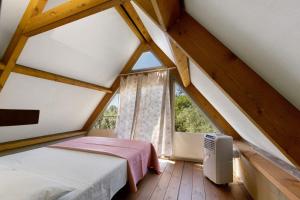 a attic room with two beds and a window at Glamping Le Ginestre in Monteverdi Marittimo