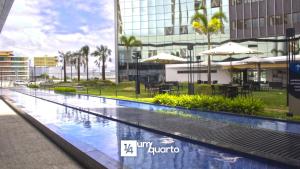 a swimming pool in front of a building at Heron Marinho Flats in Campina Grande
