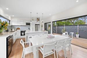 a kitchen and dining room with a white table and chairs at BYO Linen - Aireys Delight in Aireys Inlet
