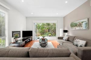 a living room with a couch and a table at Aireys Oasis in Aireys Inlet +23 photos