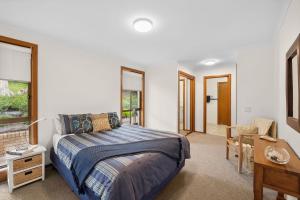 a bedroom with a bed and a table and a desk at BeachHaven in Aireys Inlet