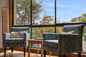 two chairs and a table in front of a window at BeachHaven in Aireys Inlet