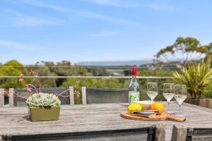 a table with glasses of wine and oranges on it at BeachHaven in Aireys Inlet