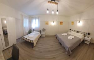 two beds in a large room with wooden floors at La Casa di Giovanni B&B in Romano D'Ezzelino