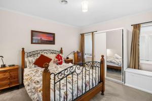 a bedroom with a bed and a mirror at Beach Living Bliss in Torquay