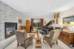 a living room with a fireplace and a piano at Beach Living Bliss in Torquay