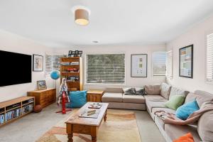 a living room with a couch and a tv at Beach Living Bliss in Torquay