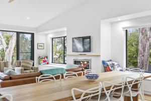 a living room with a table and chairs and a fireplace at Alto Vista in Lorne