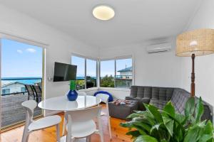 a living room with a couch and a table and chairs at Blue Surf - BYO Linen in Apollo Bay