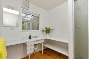 a white bathroom with a sink and a window at Blue Surf - BYO Linen in Apollo Bay +19 photos