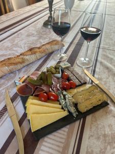 a plate of cheese and wine glasses on a table at Domaine de Marchal - chambres d'hôtes in Celles-sur-Durolle