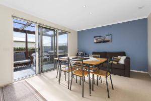 a dining room with a table and chairs and a couch at Budget By The Bay in Apollo Bay