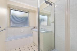 a bathroom with a shower and a sink and a tub at Budget By The Bay in Apollo Bay