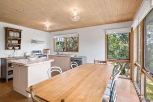 a kitchen with a wooden table and some windows at Atwood in Aireys Inlet +10 photos