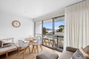 a living room with a table and chairs and a clock at Bay View Motel - Sunrise in Lorne