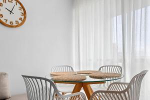 a dining room table with chairs and a clock on the wall at Bay View Motel - Sunrise in Lorne