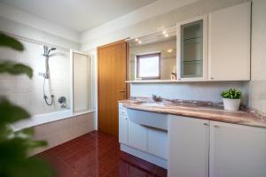a bathroom with a sink and a shower and a tub at Reihenvilla Ambachgasse in Caldaro +40 photos