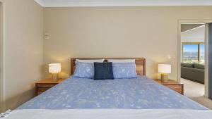 a bedroom with a bed with blue sheets and two lamps at Majestic Views in Marengo