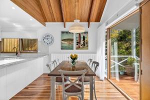a kitchen with a wooden ceiling and a table with chairs at Fern House in Lorne