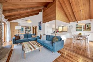 a living room with two blue couches and a table at Fern House in Lorne