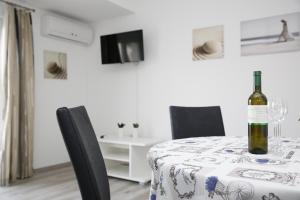 a bottle of wine on a table with chairs at Apartments Gabrijel in Vodice