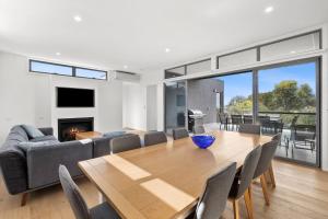 a living room with a wooden table and a couch at Aireys Sunset Beach House in Aireys Inlet
