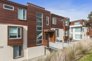 an apartment building with a wooden facade at Point Grey Apartment 13 in Lorne