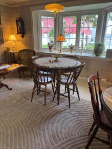 a dining room with a table and chairs and windows at Gammel stua AS in Andøya +24 photos