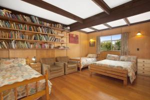 a room with two beds and a book shelf with books at Aqua Blue in Apollo Bay