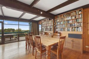a dining room with a table and chairs and bookshelves at Aqua Blue in Apollo Bay